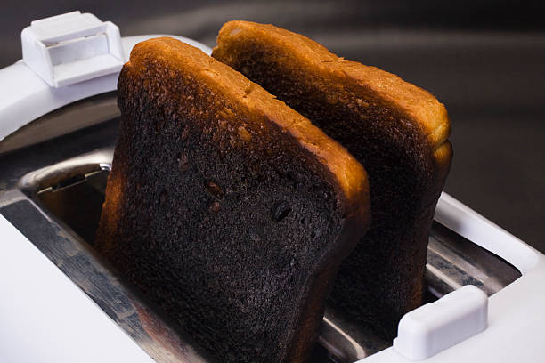 Close-up of burnt toasts in a toaster stock photo