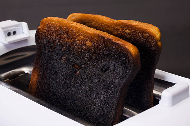 Close-up of burnt toasts in a toaster stock photo