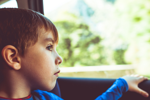 Little boy looking out of a car window