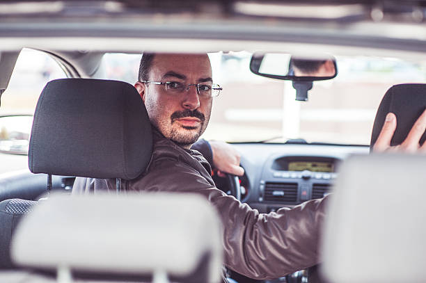 portrait d'un homme au volant d'une voiture - car driving men reversing photos et images de collection