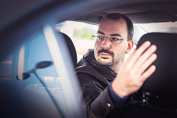 portrait d'un homme au volant d'une voiture - car driving men reversing photos et images de collection