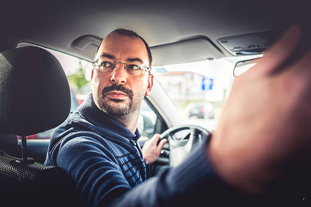 retrato de um homem dirigindo um carro - car driving men reversing - fotografias e filmes do acervo