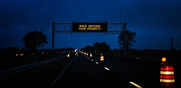 Photo of Expressway Night Construction Zone MAKE DRIVING YOUR PRIORITY Road Sign