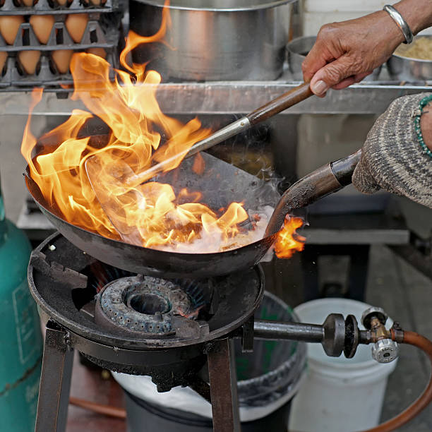 istock chef cooking with fire in frying pan 494611250