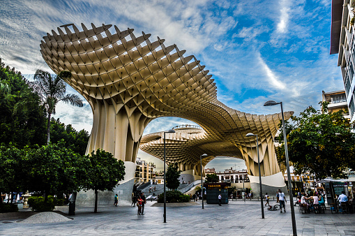Seville, Spain - August 11, 2015: Metropol Parasol is the modern architecture on Plaza de la Encarnacion in Seville, Spain. It was designed by the German architect Jurgen Mayer-Hermann. Photo taken during the day and features several people enjoying the area.