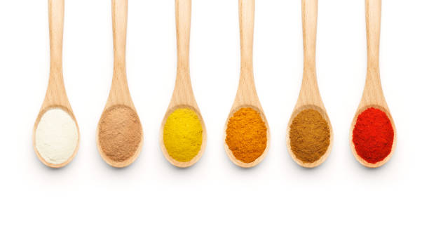 Wooden Spoon filled with colorful spices Wooden Spoon filled with colorful spices on white background red pepper powder stock pictures, royalty-free photos & images