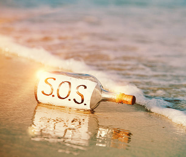 ちなみに電話サポート: 「s.o.s.」のメッセージをボトルでビーチ - message in a bottle beached bottle desert island ストックフォトと画像