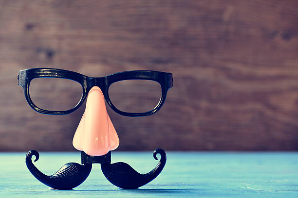 fake mustache, nose and eyeglasses on a blue surface a fake mustache, nose and eyeglasses on a rustic blue wooden surface caricature photos stock pictures, royalty-free photos & images