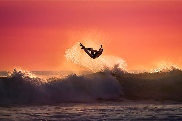 surfer-jumping auf einer welle - waves crashing stock-fotos und bilder