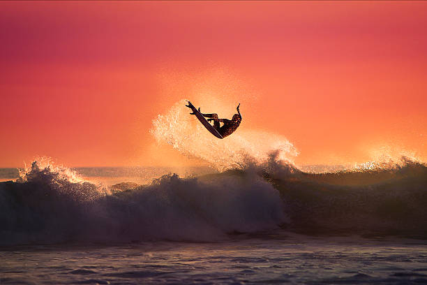 surferka skakać na wierzchu fali - surf zdjęcia i obrazy z banku zdjęć