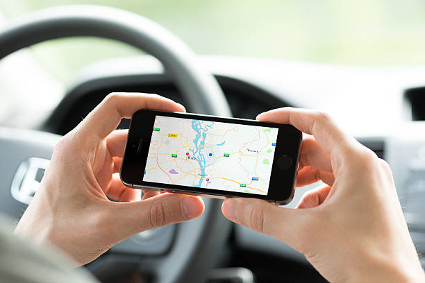 smartphone mapping tout en voiture - iphone google holding telephone photos et images de collection