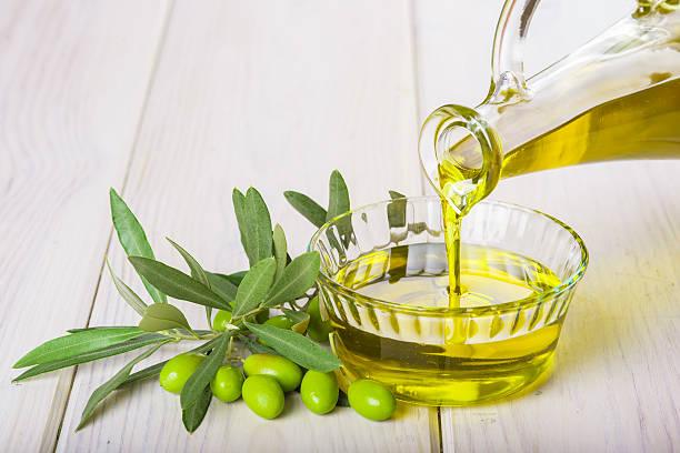 istock Bottle pouring virgin extra olive oil in a bowl 494635724