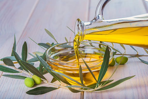 istock Bottle pouring virgin extra olive oil in a bowl 494637108