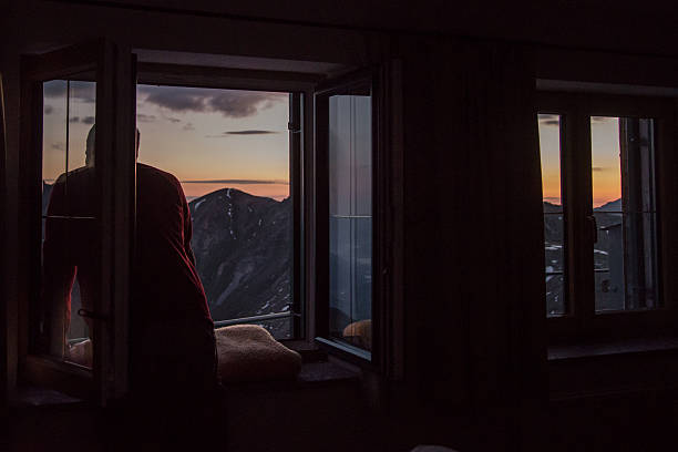 istock looking out the window at sunrise over mountain 494638488