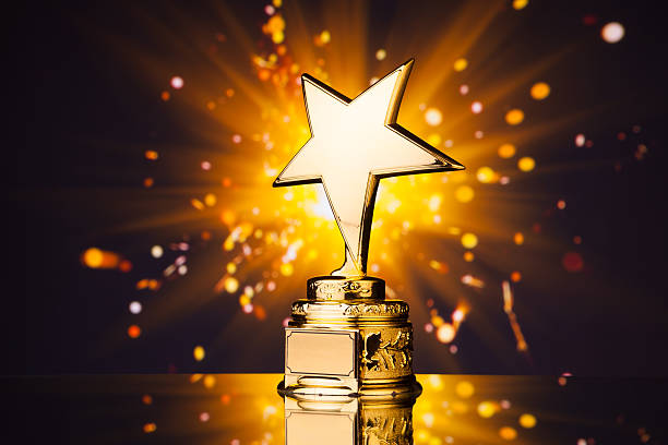 gold star trophy against shiny sparks background gold star trophy against shiny sparks background emitted from sparkler gold trophy stock pictures, royalty-free photos & images