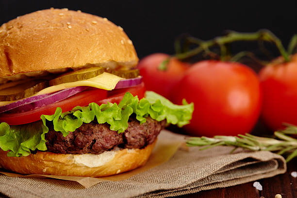 istock Big juicy beef burger on background tomatoes and herbs 494640074