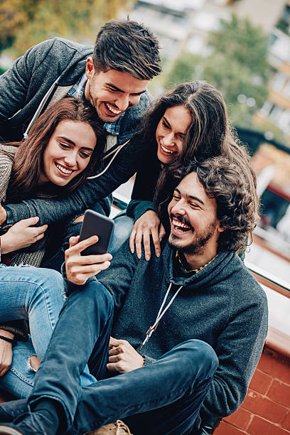 istock Young man showing smart phone to his friends 494646300