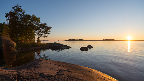 Rocky coast in a small bay of the island Yxlan in the archipelago near Stockholm in Sweden with the sunset