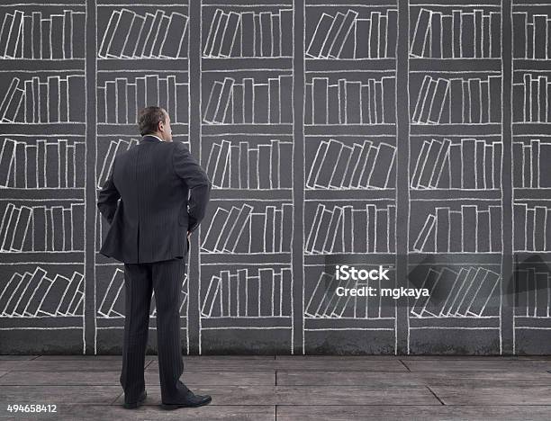 Businessman With Bookshelf Sketched On The Wall Stock Photo - Download Image Now - Shelf, Book, Bookshelf