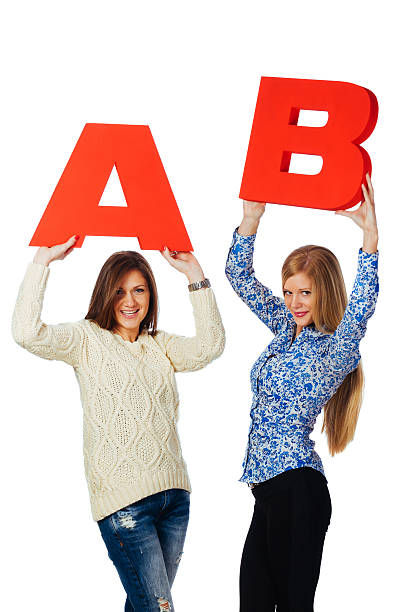 istock Cheerful  women holding red A and B letters 494658490