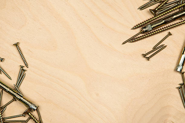 istock Gold screws on diagonal with wood background 494660684