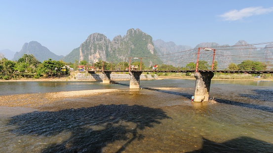Rope wooden bridge over river song in Vang vieng, Laos.