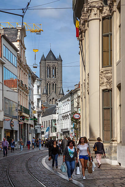 Ghent, Belgium - September 10, 2015: View on St.Nicholas' church from Veldstraat, Ghent, with people shopping. tram rails in the middle of the street.