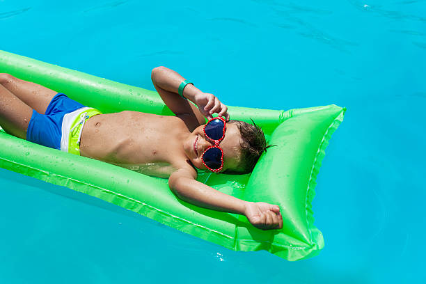 Happy boy floating on swim ring in the swimming pool