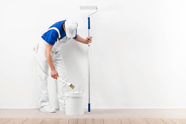 istock Painter man with paitroller takes color with brush roller 494669494