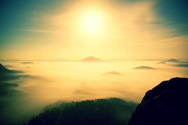 Midnight. Full moon night in a beautiful mountain, heavy  fog Full moon night with sunrise in a beautiful mountain of Bohemian-Saxony Switzerland. Sandstone peaks and hills increased from foggy background contrail moon on a night sky stock pictures, royalty-free photos & images