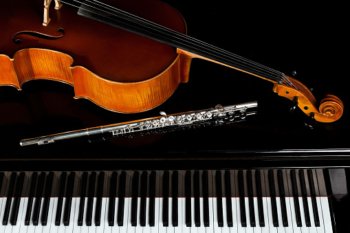 Musical instruments lying on the piano in dark colors