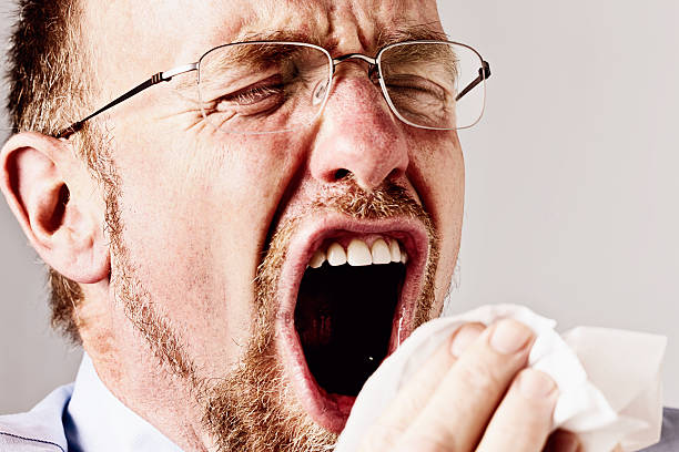 istock Bearded man sneezing into handkerchief 494675879