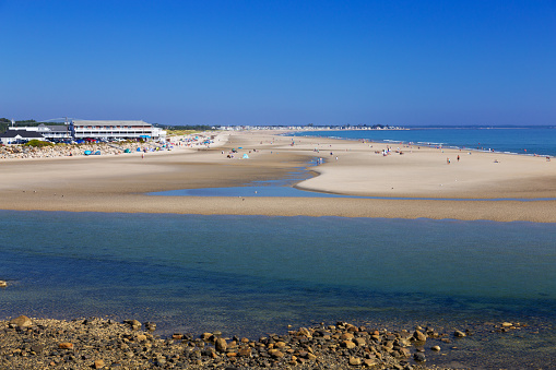 Ogunquit Beach lit by morning sun, Maine, New England, USA. Rocky shore, sandy beach, turquoise ocean waters, sunbathing people and vivid clear blue sky are in the image. The beach spans between Ogunquit and Wells. Canon EOS 6D (full frame sensor) and Canon EF 24-105mm f/4 L IS lens. Polarizing filter.