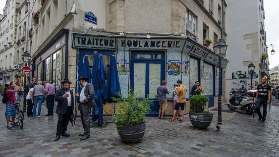 Paris, France - August 31, 2015: People gather on the corner of Rue des Rosiers and Rue des Ecouffes in the historic Jewish neighborhood of Marais.