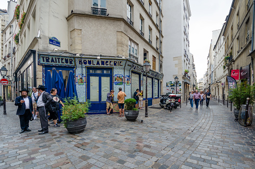 Paris, France - August 31, 2015: People gather on the corner of Rue des Rosiers and Rue des Ecouffes in the historic Jewish neighborhood of Marais.