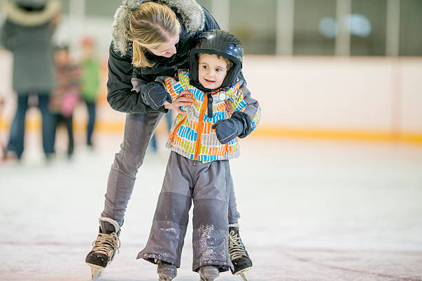 istock Mother Helping Her Son Learn to Ice Skate 494705652