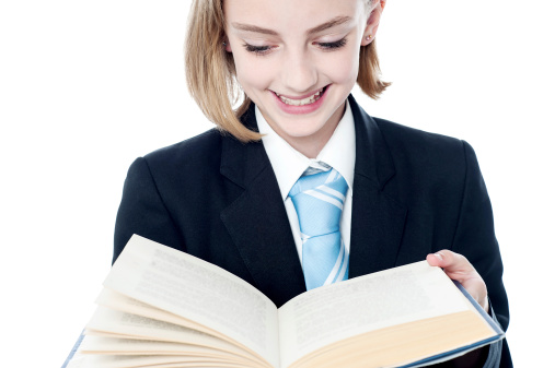 Young girl in business suit reading a book