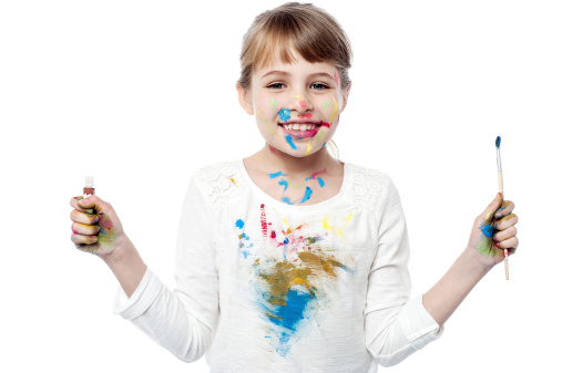 Adorable young girl holding paint and brush