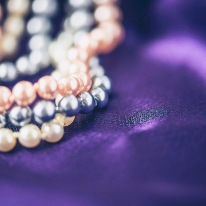 Strands of pearl jewelry on rich purple satin