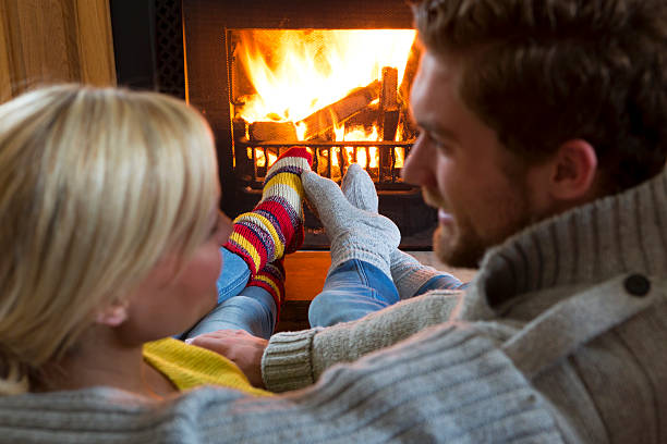 istock Young Couple Warming Feet by the Fire 494711253
