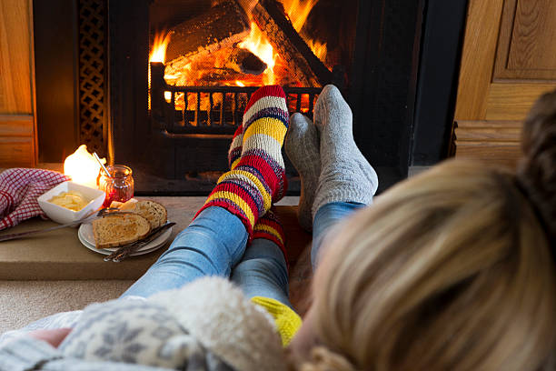 istock Young Couple Warming Feet by the Fire 494711259