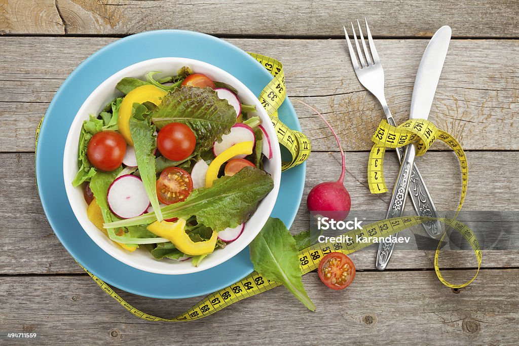 Fresh healty salad Fresh healty salad on wooden table and silverware. View from above Above Stock Photo
