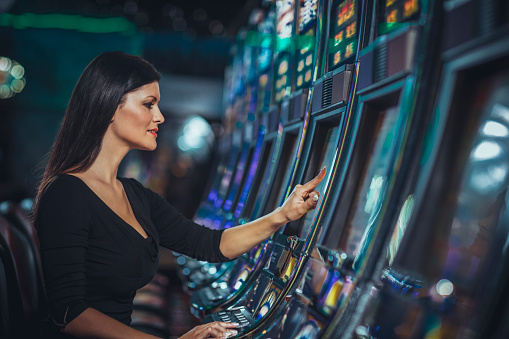 woman playing slot machine in casino