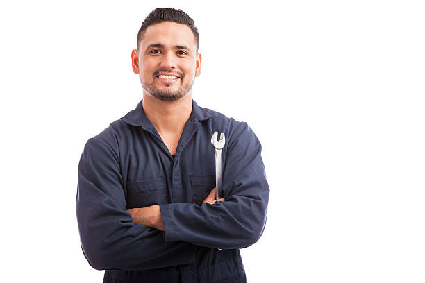 Ready to fix your broken car Portrait of a young mechanic holding a wrench and smiling, ready to fix cars repairman stock pictures, royalty-free photos & images