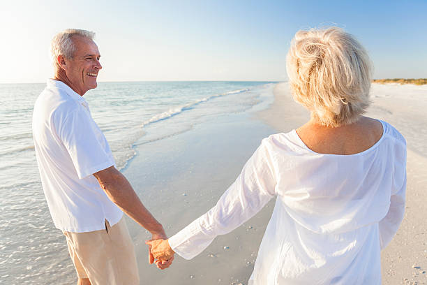 istock Happy Senior Couple Walking Holding Hands Tropical Beach 494726924