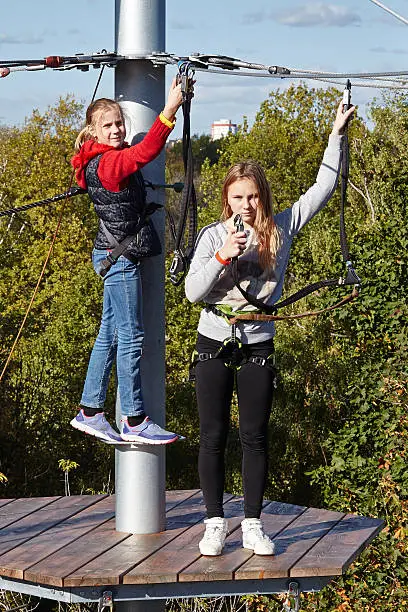 Girls run an obstacle course in climbing amusement park