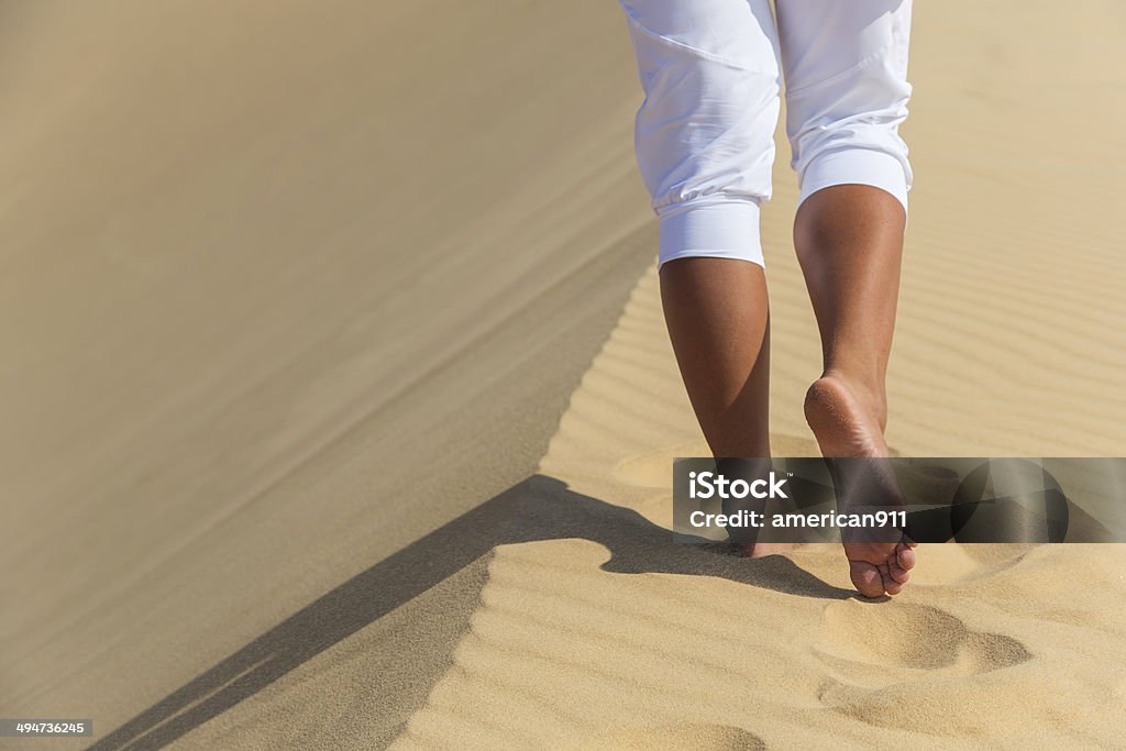 Women's beautiful smooth legs on white sand beach Adult Stock Photo
