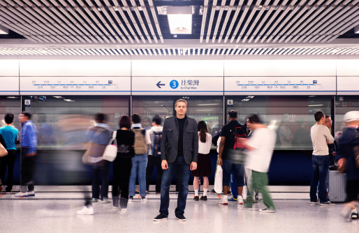 This is a horizontal, color photograph of a Swiss man standing out from the crowd in the Hong Kong Subway.http://i256.photobucket.com/albums/hh165/Dakandikid/banner_HK.jpg