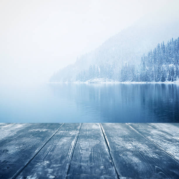 fundo de inverno. piso de madeira e paisagem de inverno sobre fundo desfocado - winter lake snow water - fotografias e filmes do acervo
