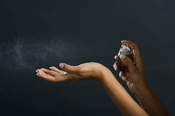 Woman applying perfume on her hand stock photo